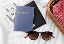 passport and bancnote beside luggage