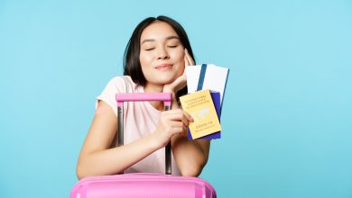 smiling dreamy asian tourist girl thinks of travelling holding passport and tickets coronavirus inte