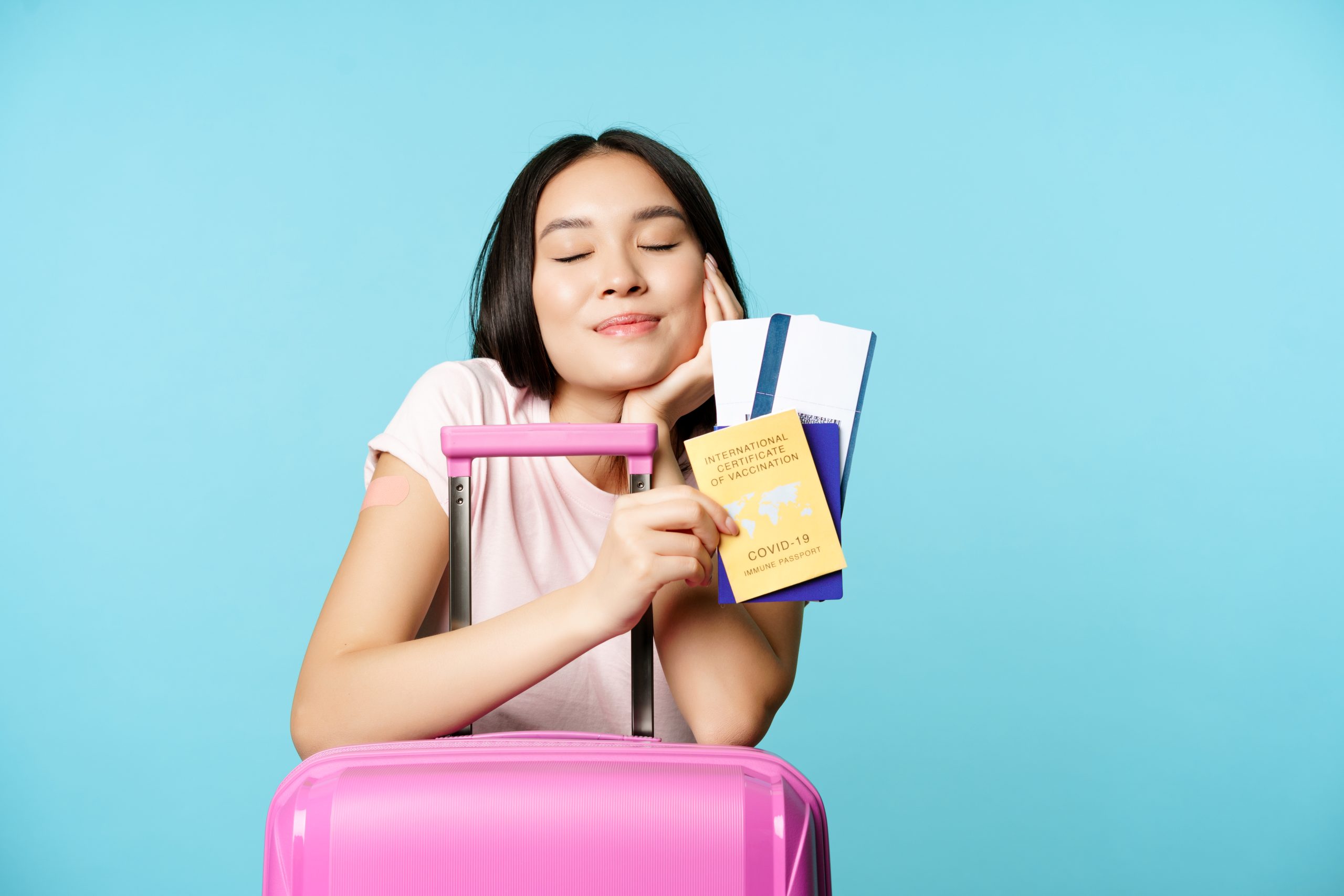 smiling dreamy asian tourist girl thinks of travelling holding passport and tickets coronavirus inte scaled