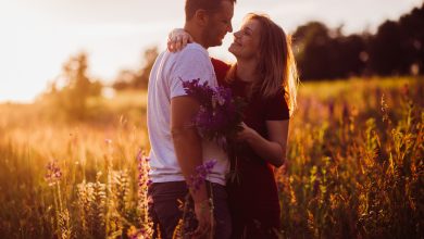 cheerful couple hugs each other tender standing on the green field