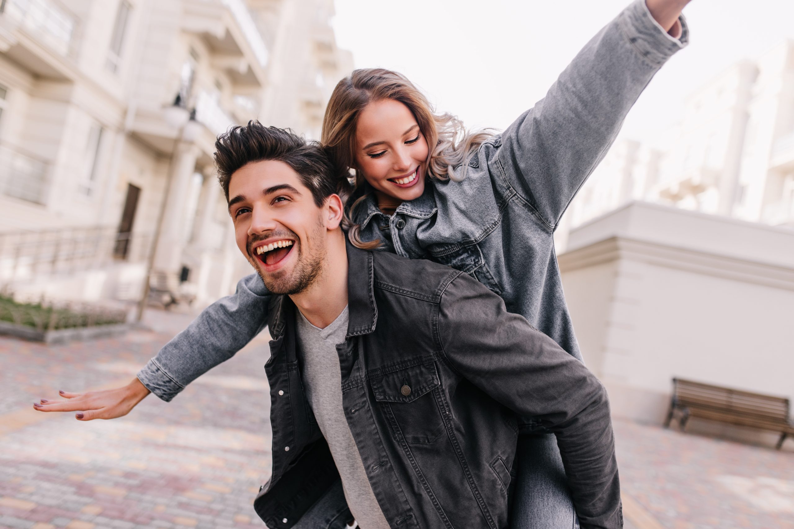 excited man in black denim jacket chilling with girlfriend outdoor portrait of happy couple exploring city scaled