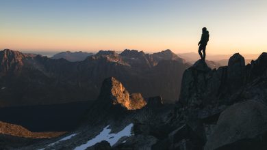 silhouette of a person standing on the top of a hill under the beautiful colorful sky in the morning