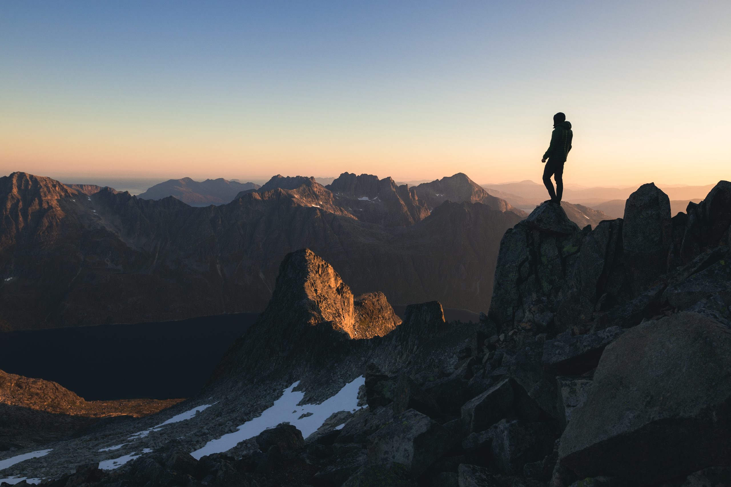 silhouette of a person standing on the top of a hill under the beautiful colorful sky in the morning scaled