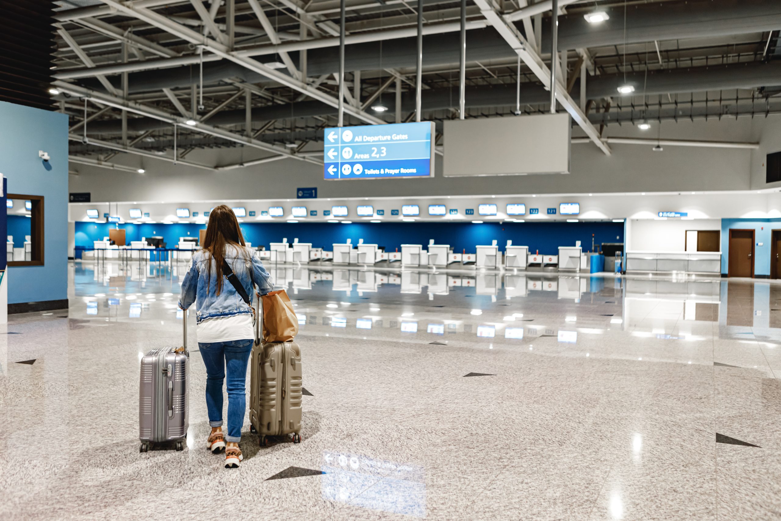 woman walks along the airport with suitcases scaled