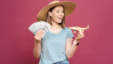 woman holding money wooden plane