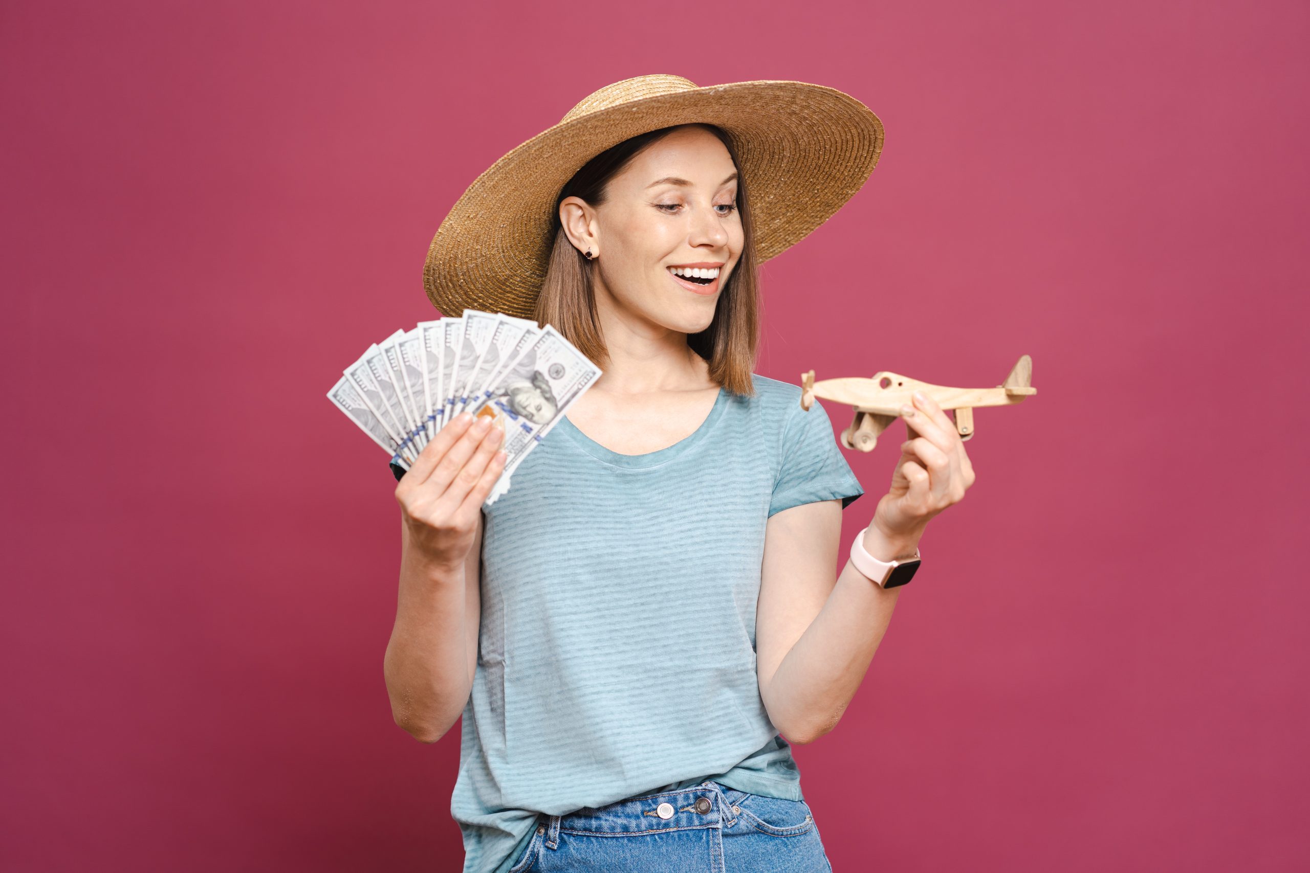 woman holding money wooden plane scaled