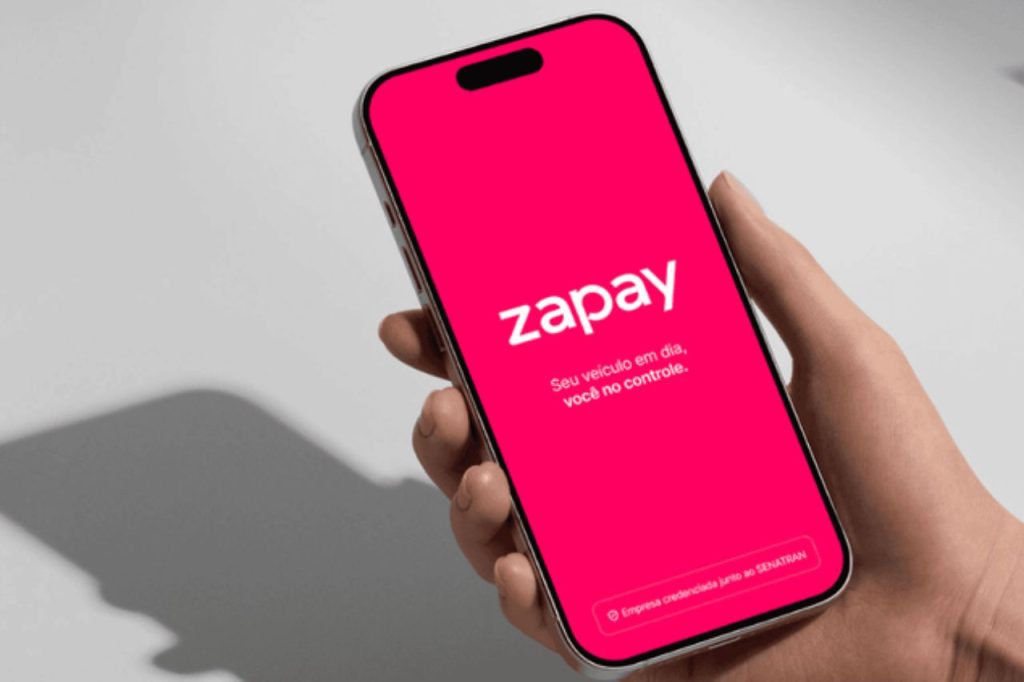 Pessoa segurando um smartphone com a tela exibindo o aplicativo Zapay, representando tecnologia e praticidade em consultas e pagamentos relacionados a placas de veículos.