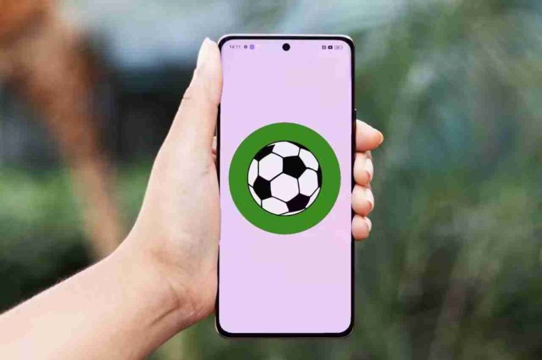Smartphone exibindo ícone de futebol na tela, representando a possibilidade de assistir futebol pelo celular com aplicativos práticos e acessíveis em qualquer lugar.